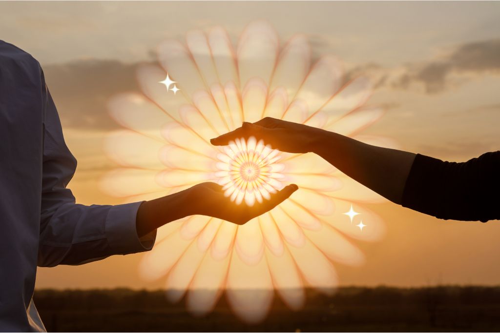 Psychedelic use in relationships. The concept of a love relationship between people, depicted by their hands interacting with a floral pattern expanding from the space between their hands. There is a sunset glow beyond them.
