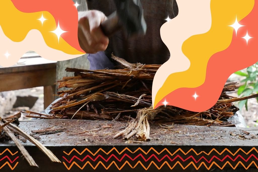 Ayahuasca Ceremonies. A person preparing ayahuasca with a hammer. There are graphics of groovy retro streams of colors emanating from the ayahuasca tree, with some stars dotted around it. There are also some graphics of zig-zags along the bottom. The colors of the graphics are red/peachy-red, orange/mustard-yellow, and off-white.