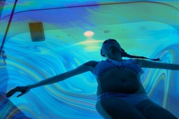 Mystical Experiences. An image of someone in the suggestion of a sensory deprivation tank. The image is blueish and dark, with some psychedelic patterns in the water. 
