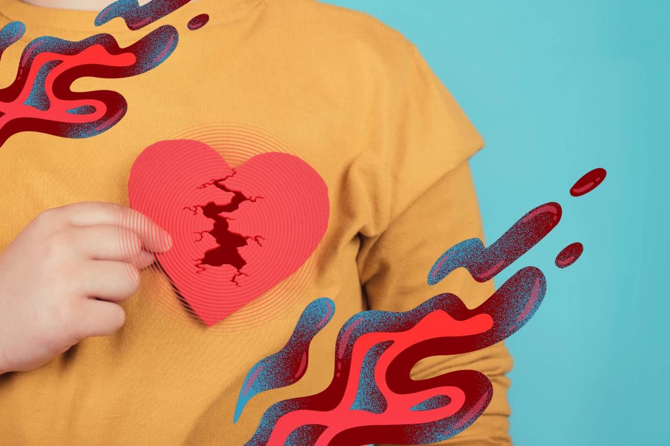 Microdosing and heart health. A turquoise background with a close-up of the left side of a person's torso, facing the camera. They are wearing a plain sunny yellow-orange t-shirt, and are holding a red heart cutout in front of where their heart is. There is a crack in the heart, and there are blood-coloured psychedelic liquid patterns floating around it.