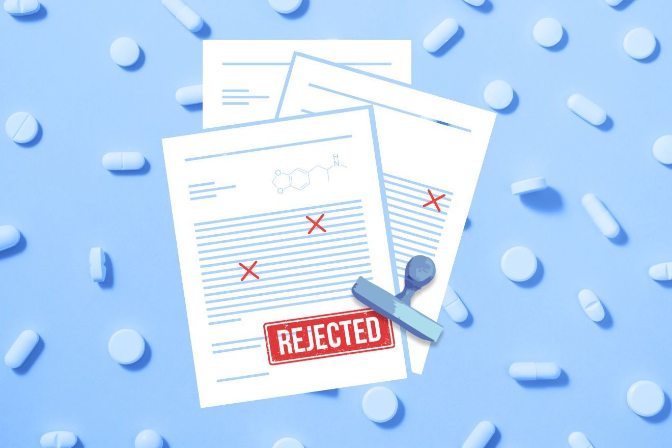 FDA's decision. A top-down view of documents with a large red 'REJECTED' stamp on a blue background with pills scattered around, scientific document, rejection letter, failed medicine