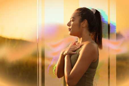 Holotropic Breathwork and Psychedelic Therapy. The image shows a woman standing outdoors at sunset, with her eyes closed and hands resting on her chest in a gesture of calm or meditation. Warm golden tones dominate the composition, with overlays of soft pinks, purples, and greens adding a surreal, dreamy quality. Vertical light streaks and subtle digital effects enhance the ethereal, introspective atmosphere of the scene.