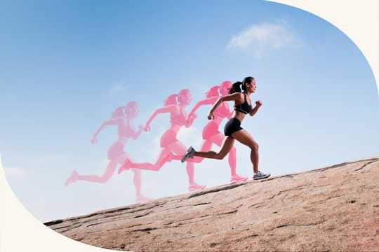 Psychedelics for athletes. This image captures a dynamic motion blur effect of a woman running up a rocky surface, with multiple ghost-like images of her in varying stages of movement trailing behind her. The primary colors include a bright blue sky with soft white clouds, contrasting with the earthy beige of the rocks. The runner is dressed in athletic gear—black sports bra and shorts—with her hair pulled back in a ponytail. The composition uses the motion blur technique to emphasize speed and energy, creating a sense of movement and progression across the frame. The background has a clean, minimal look, allowing the runner's motion to stand out.